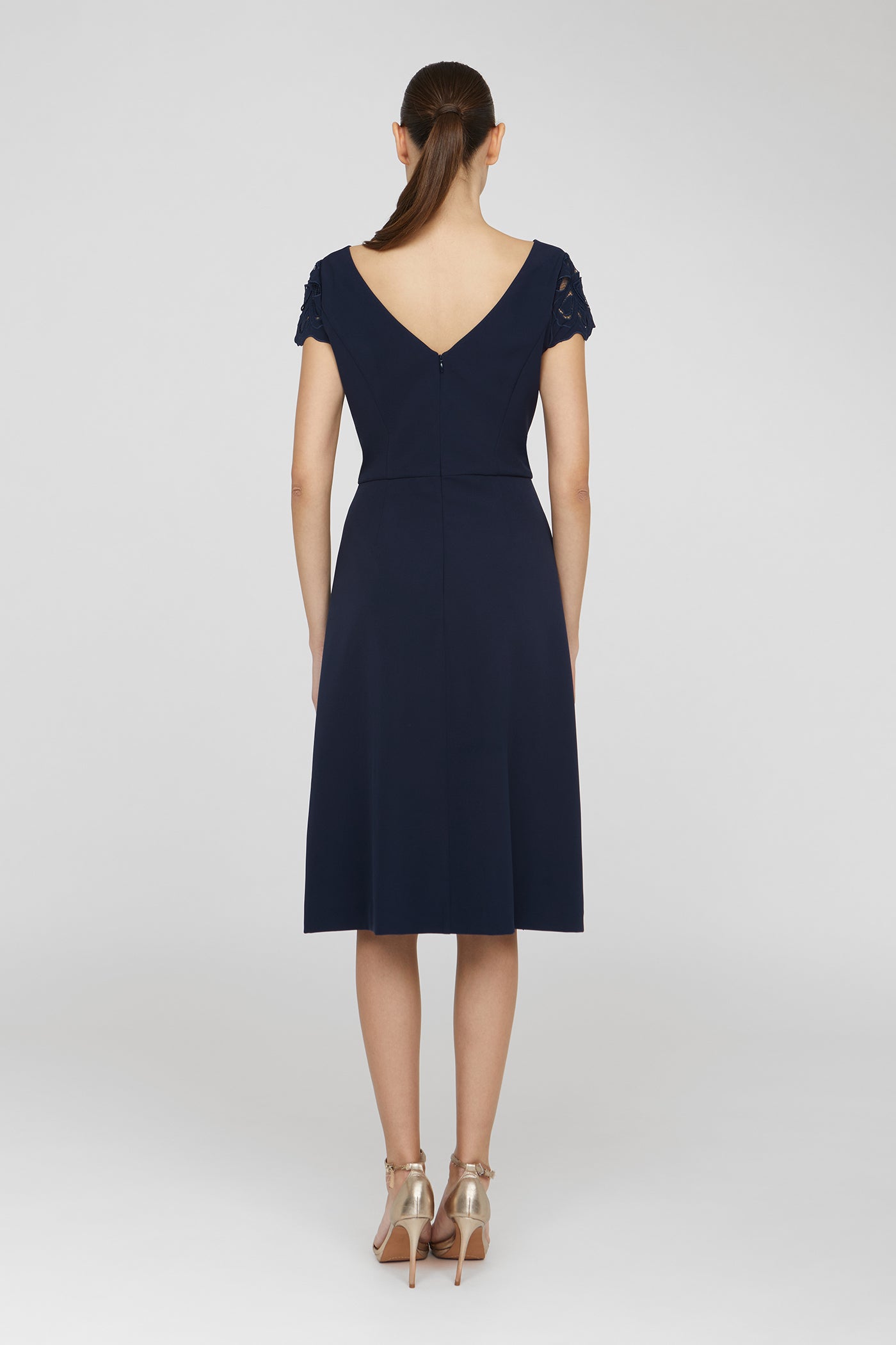 Navy blue dress worn by a model on a white background