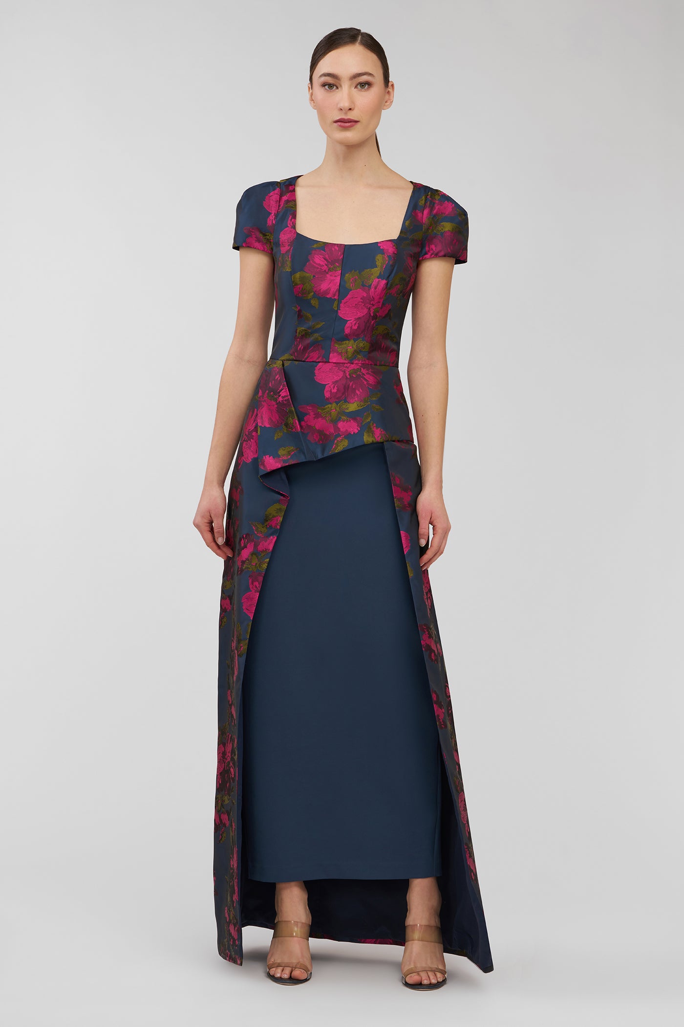 Woman wearing a floral dress with a layered design on a white background