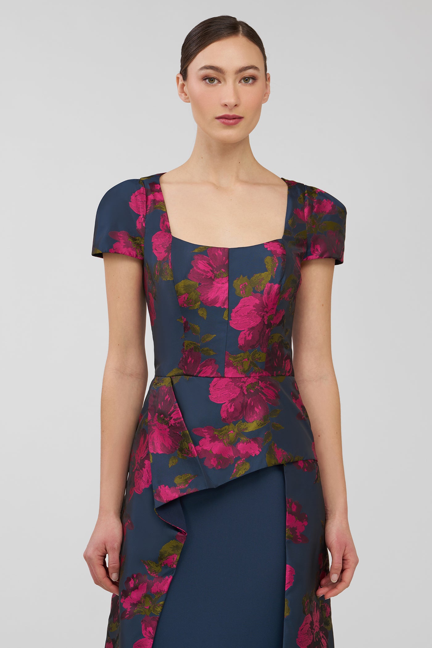 Woman wearing a floral dress with a plain background