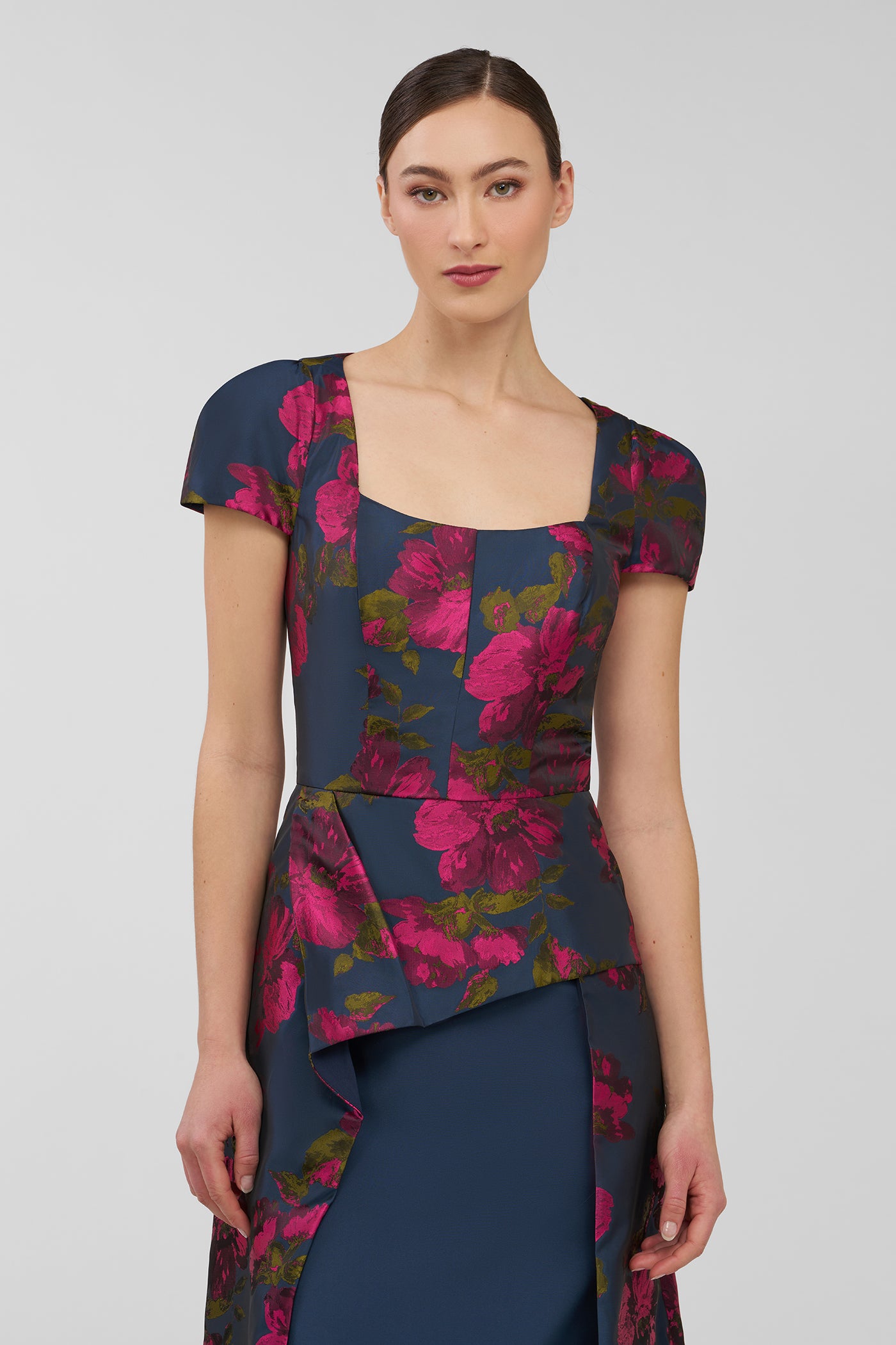 Woman wearing a floral dress with a plain background