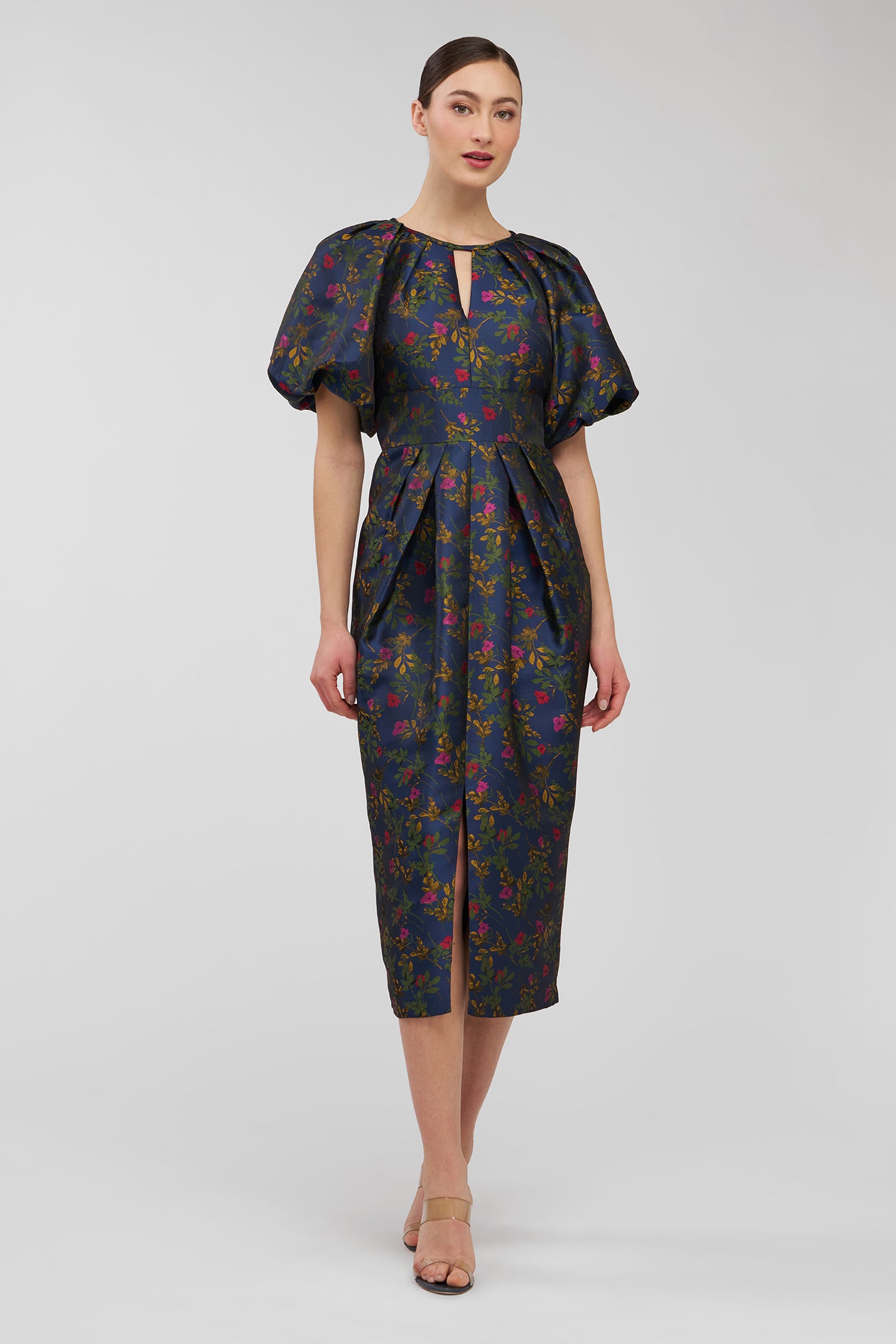 Woman wearing a dark floral dress on a light gray background