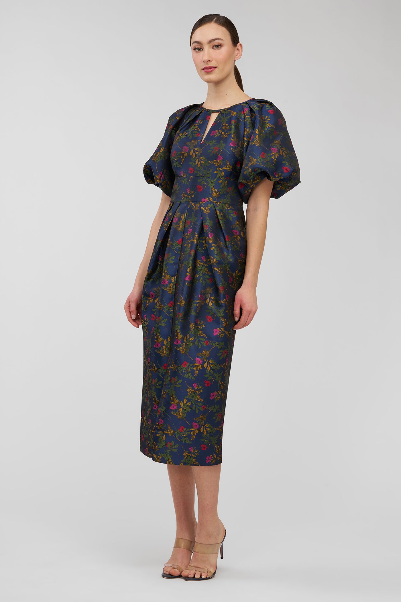 Woman wearing a dark floral dress on a white background