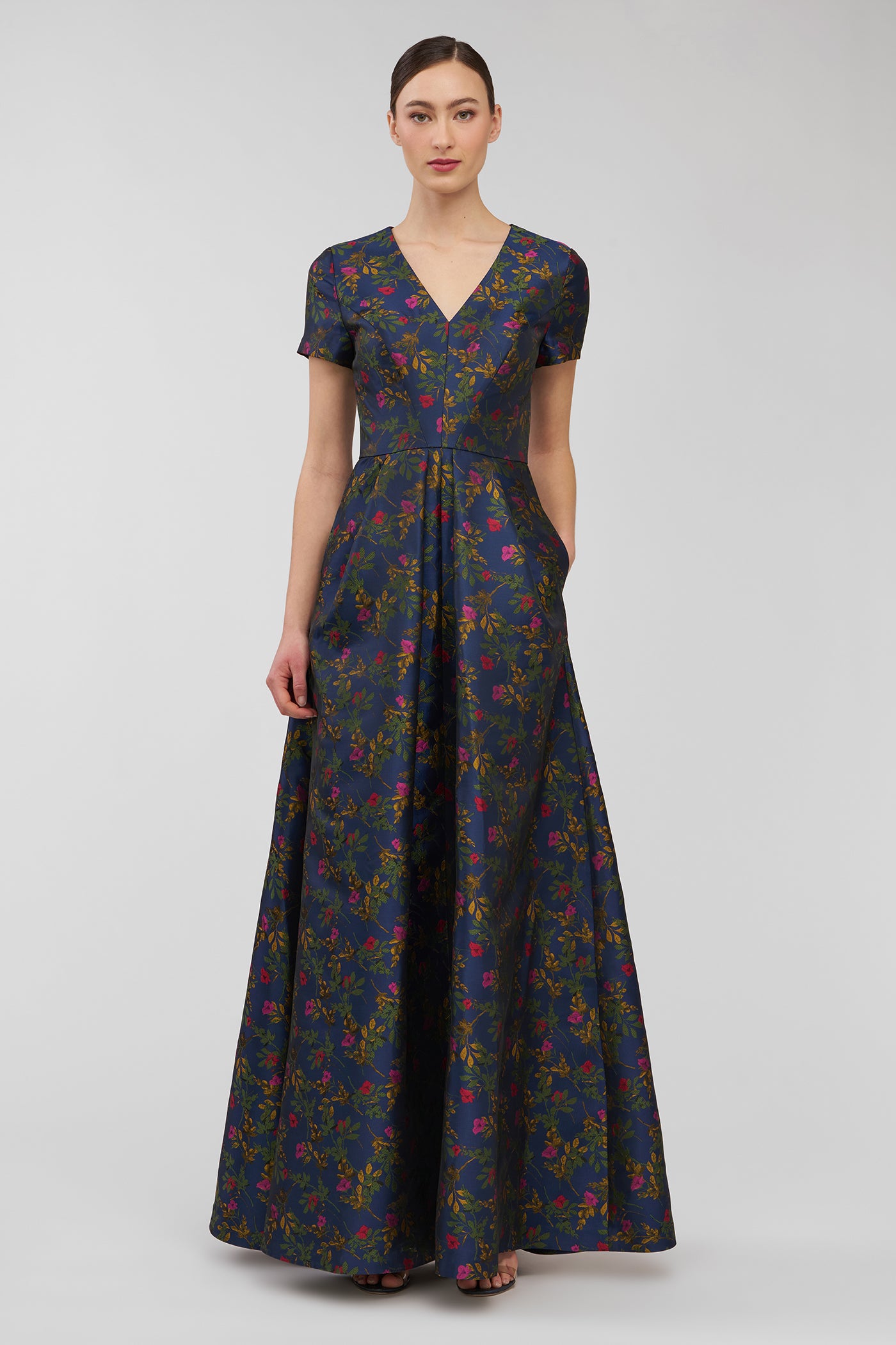 Woman wearing a floral-patterned dress on a light gray background