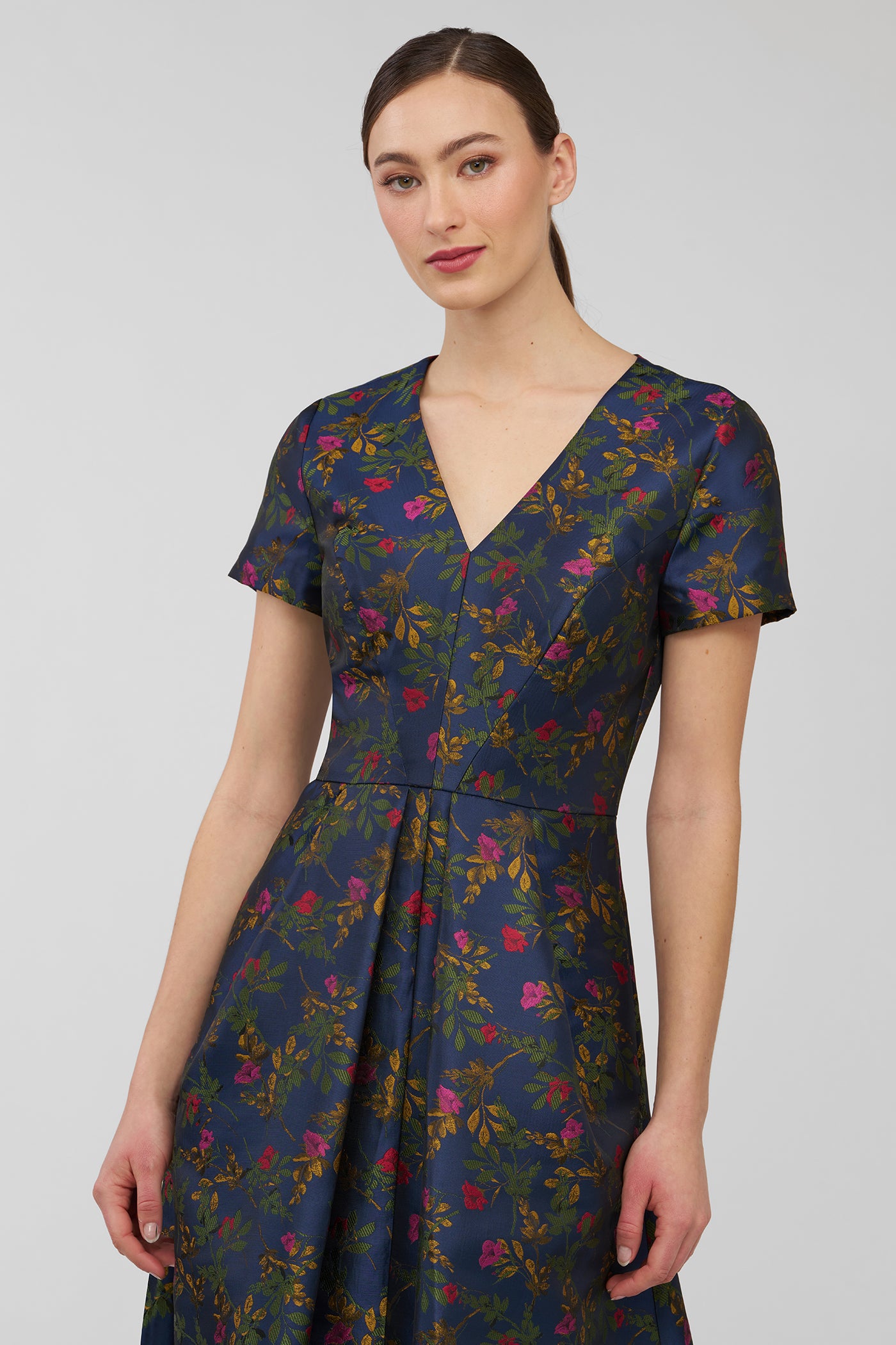 Woman wearing a dark blue floral dress against a plain background