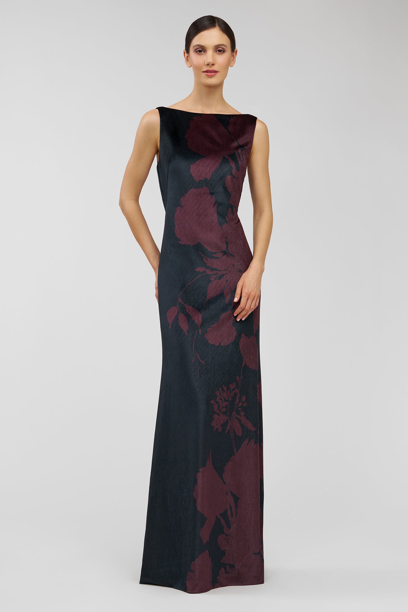 Woman wearing a black evening gown with red floral patterns on a white background