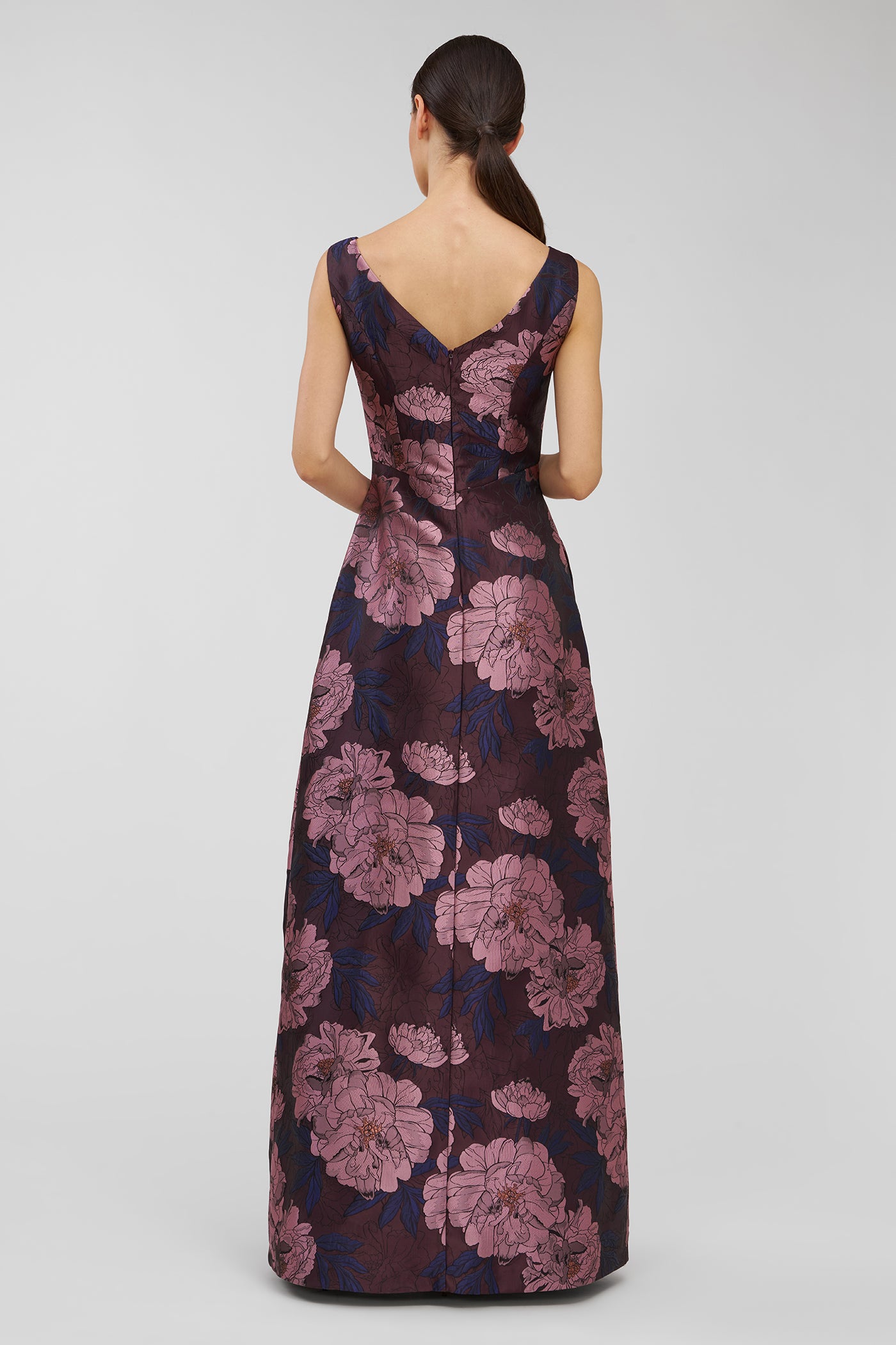 Woman wearing a floral patterned dress on a plain background