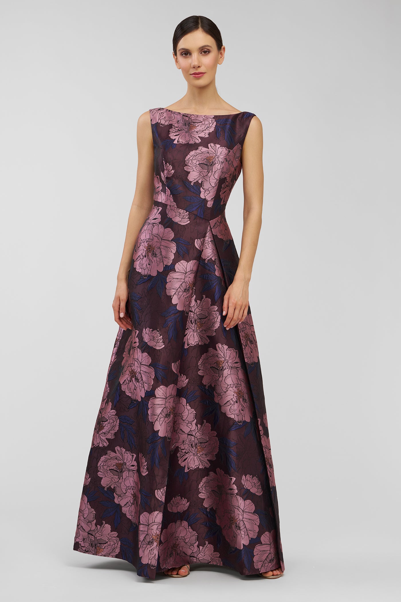 Woman wearing a floral patterned dress on a plain background