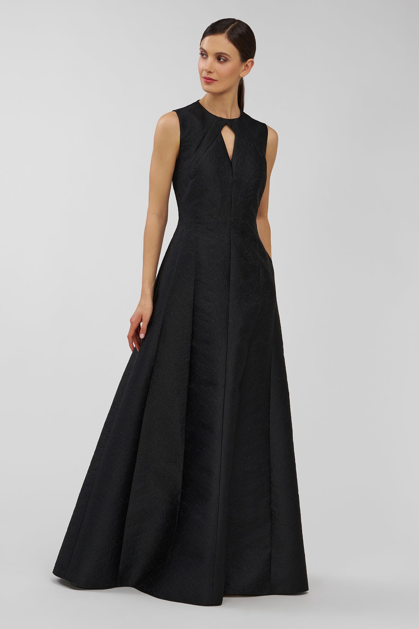 Woman wearing a black sleeveless gown on a gray background