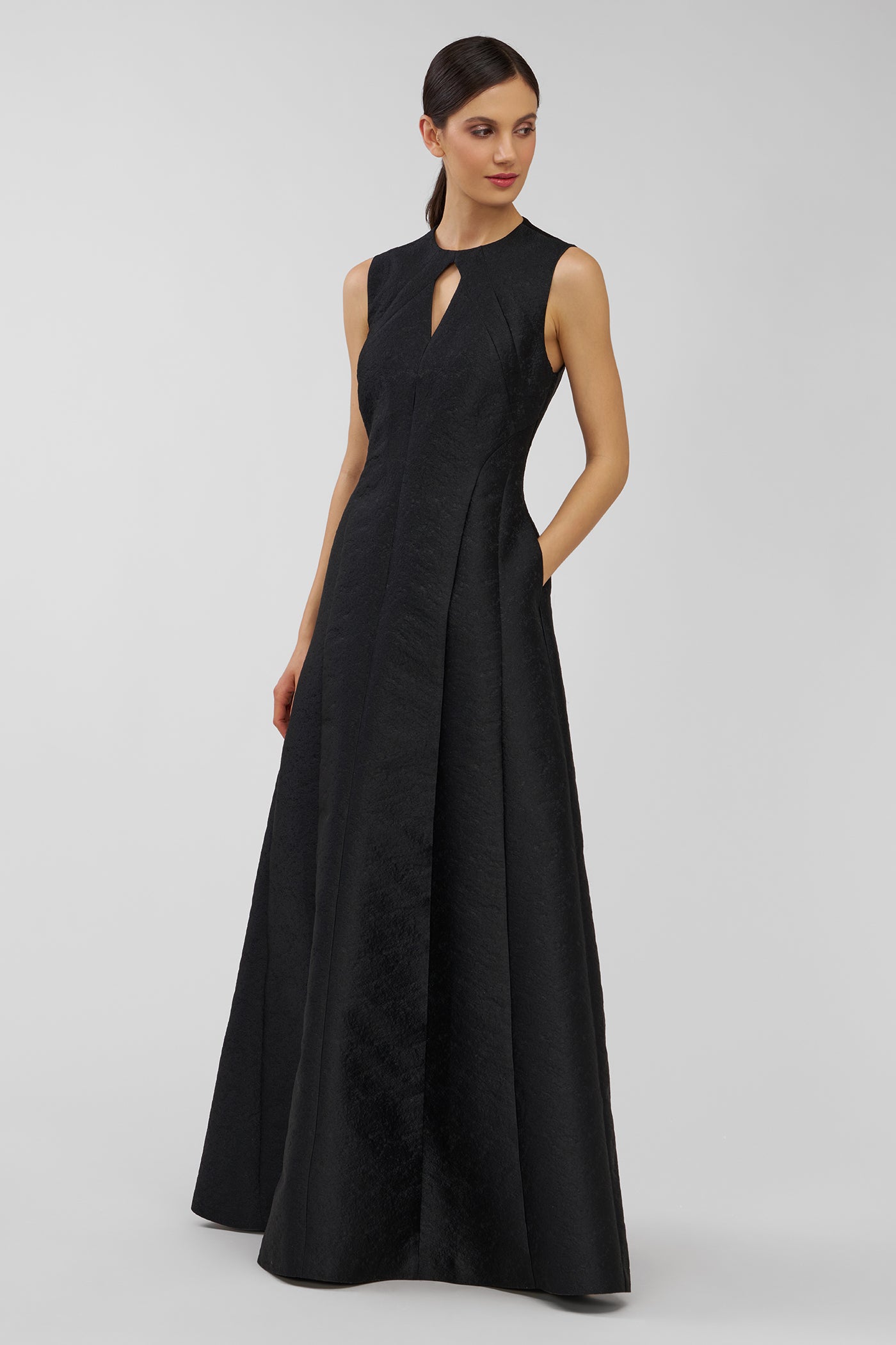 Woman wearing a black sleeveless dress on a light gray background