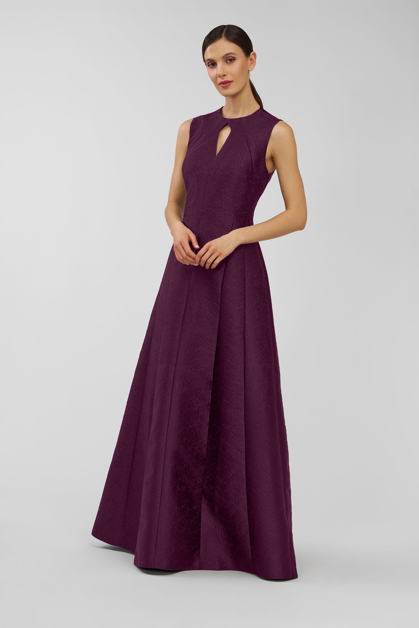 Woman wearing a purple evening gown on a light gray background