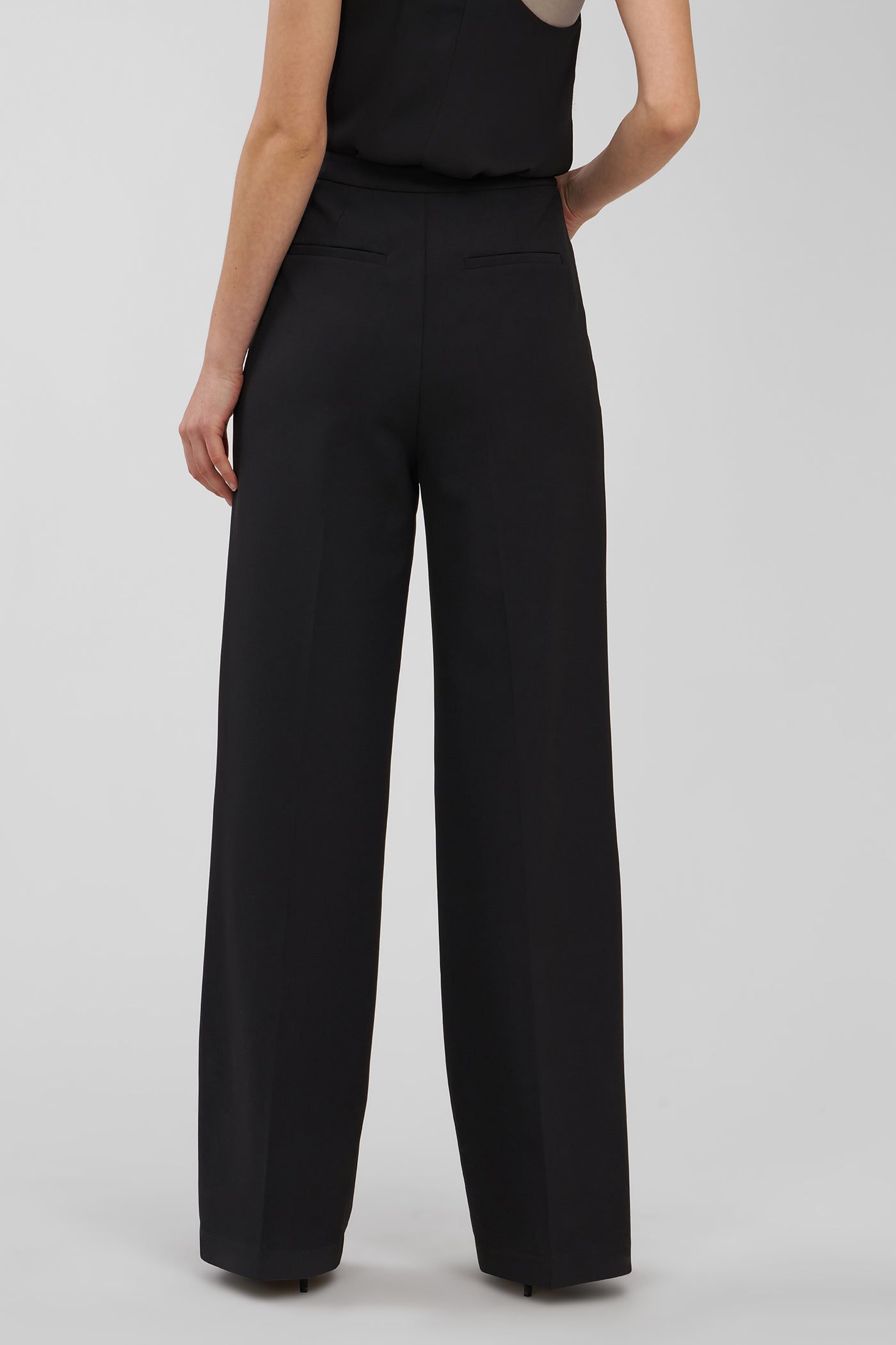 Black wide-leg pants worn by a person on a white background
