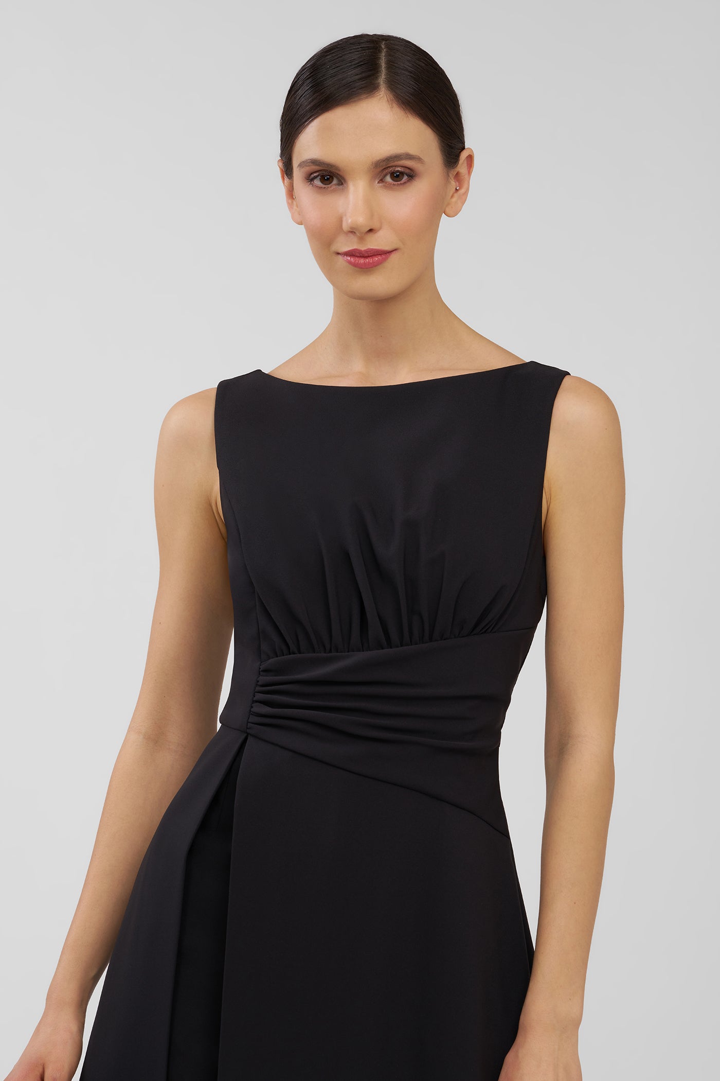 Woman wearing a black walk thru jumpsuit against a plain background