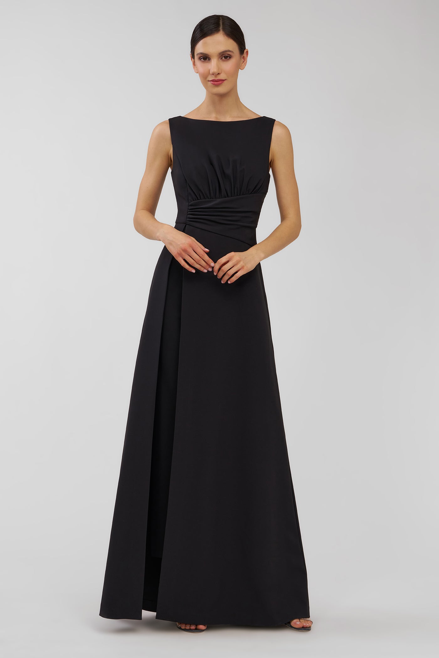 Woman wearing a black sleeveless walk thru jumpsuit on a white background